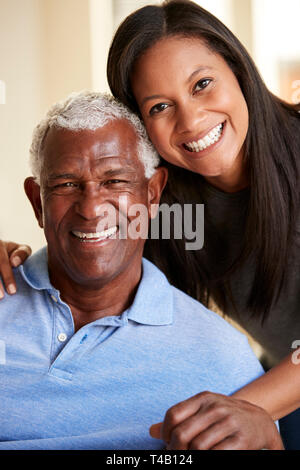 Portrait von lächelnden älteren Vater umarmt von erwachsenen Tochter zu Hause Stockfoto