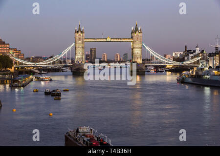 Vollständige Ansicht der Tower Bridge hell erleuchtet mit seiner Reflexion auf der Themse bei Dämmerung Stockfoto