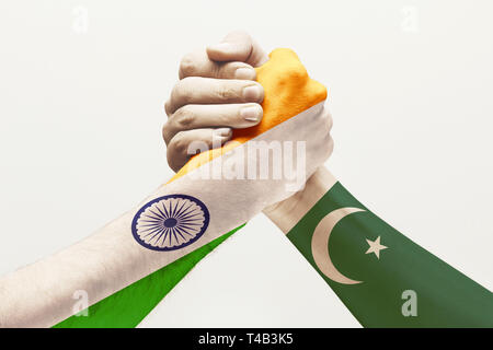 Intensive Kommunikation. Zwei männliche Hände konkurrieren im Armdrücken in Pakistan und Indien Fahnen studio Farbige isoliert auf weißem Hintergrund. Konzept der wirtschaftlichen und politischen Beziehungen, Uneinigkeit. Stockfoto