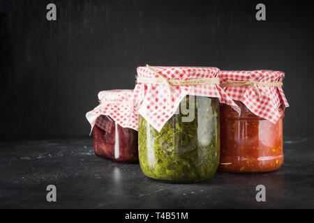 Verschiedene Arten von der Dose hausgemachter Sauce für Fleisch, adjika von der Tomate, Sauerampfer, tkemali aus der Pflaume. Hausgemachte Vorbereitungen, Hausaufgaben und Tradit Stockfoto