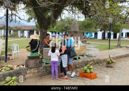 PARATY, Brasilien - 14. OKTOBER 2014: Street Hersteller verkauft frische Kokosnüsse von Paraty (Bundesstaat Rio de Janeiro). Die koloniale Stadt reicht bis ins Jahr 1667 zurück und ist Stockfoto