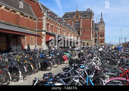 AMSTERDAM, NIEDERLANDE, 9. Juli 2017: Die Menschen besuchen Fahrrad Parkplatz vor dem Hauptbahnhof Amsterdam (Centraal). Niederlande ist extrem friendl