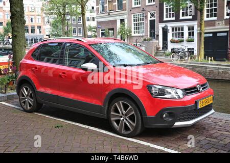 AMSTERDAM, NIEDERLANDE, 8. Juli 2017: Roter VW Polo Cross kleine Stadt Auto durch den Kanal in Amsterdam geparkt. Die Niederlande haben 528 registrierte Autos Stockfoto