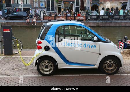AMSTERDAM, NIEDERLANDE, 8. Juli 2017: Smart Fortwo kleine Stadt Auto elektrische Version durch den Kanal in Amsterdam geparkt. Die Niederlande haben 528 registrierte c Stockfoto