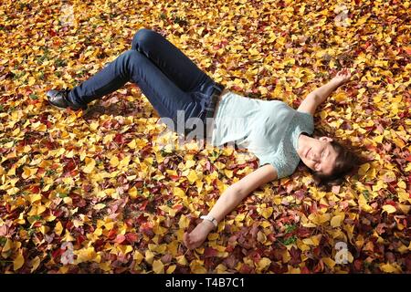 Frau genießt Gelb Herbst ginkgo Baum Blätter in Osaka, Japan. Stockfoto