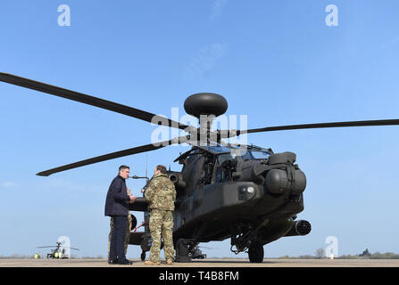 Verteidigungsminister Gavin Williamson spricht mit Senior flying intructor für Kampfhubschrauber Gewalt Tim Pittaway neben einem Apache Hubschrauber in Wattisham Flugplatz in Suffolk, wie sie in den Baltischen Staaten für einen dreimonatigen Einsatz. Stockfoto