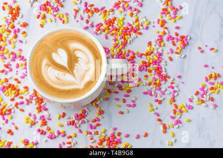 Tasse Kaffee mit bunten süssen bonbons Hintergrund Draufsicht frischen und gesunden Tee Stockfoto