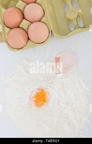 Gebrochene Eier auf das gesiebte Mehl Stockfoto
