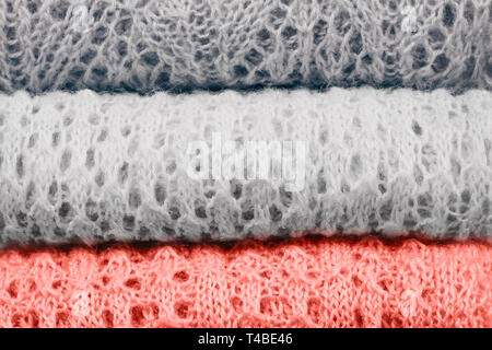 Stilvolle gestrickt, pastellfarbenen Pullover und eins in der Farbe des Jahres 2019 im Stapel gefaltet. Close Up, kopieren. Stockfoto