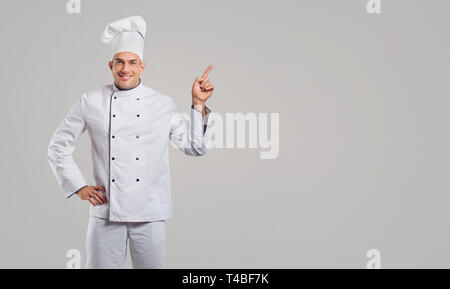 Der Kerl, der Koch in weißen Kleidern lächeln Stockfoto