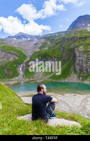 Ein junger Mann Enyojing der Blick auf den See namens Nassfeld Speicher im Nationalpark Hohe Tauern in Österreich Stockfoto