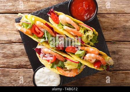 Frischer Mais Tacos mit Garnelen, frisches Gemüse und Saucen close-up auf dem Tisch. horizontal oben Ansicht von oben Stockfoto