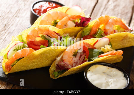 Frischer Mais Tacos mit Garnelen, frisches Gemüse und Saucen close-up auf dem Tisch. Horizontale Stockfoto