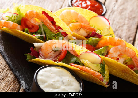 Köstliche Mexikanische Tacos mit Garnelen und Gemüse close-up auf den Tisch serviert mit Saucen. Horizontale Stockfoto