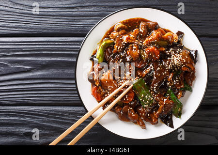 Chinesisch Leckere Pfannengerichte vom Schwein mit mun Pilzen und Gemüse close-up auf einem Teller auf den Tisch. Horizontal oben Ansicht von oben Stockfoto