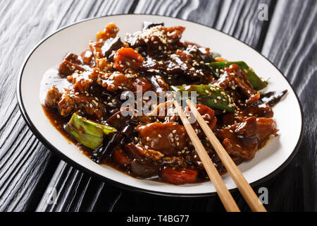 Die koreanische Küche rühren - gebratenes Schweinefleisch mit mun Pilzen und Gemüse in eine dicke Sauce closeup auf einem Teller auf den Tisch. Horizontale Stockfoto