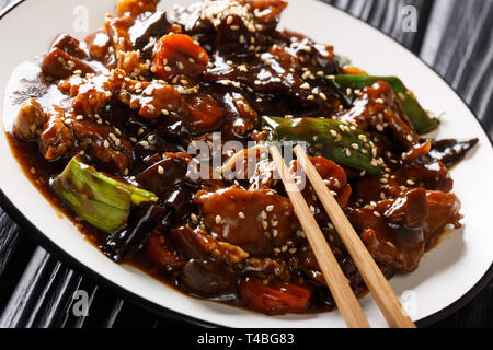 Asiatischer Schweinebraten mit mun Pilzen und Gemüse in einer süß-saurer Sauce closeup auf einem Teller auf den Tisch. Horizontale Stockfoto