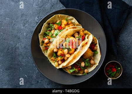 Flapjack mit Aloo Gobi und Kichererbsen auf dunklem Hintergrund der Ansicht von oben Stockfoto