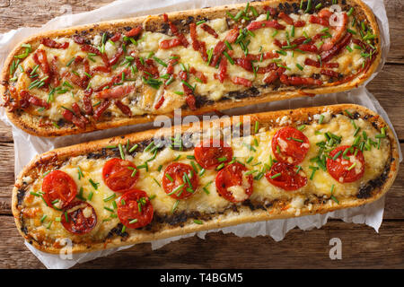 Close-up Pizza, Sandwiches mit Schinken, Pilzen, Tomaten und Käse auf einem Pergament auf den Tisch. Horizontale Draufsicht von oben Stockfoto