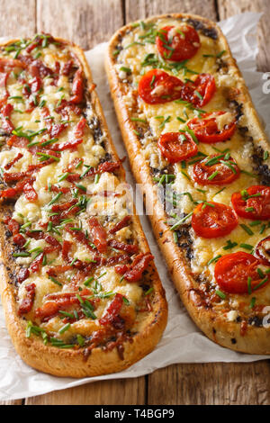 Zwei offene Kasserolle Sandwiches mit Schinken, Pilzen, Tomaten und Käse close-up auf dem Tisch. Vertikale Stockfoto