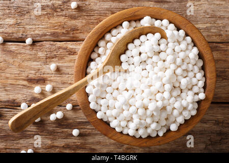 Trockene pearl Tapioka Zutat für das Kochen closeup in einer Schüssel auf einem Holztisch. Horizontal oben Ansicht von oben Stockfoto