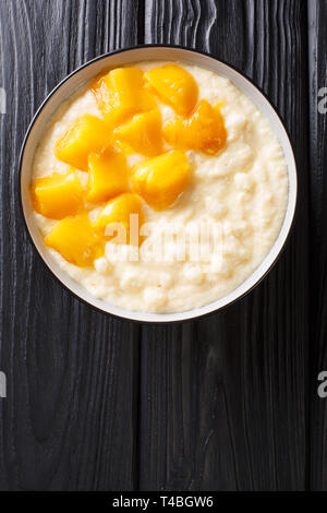 Süße tapioka Pudding mit Kokosmilch und frischer Mango close-up in einer Schüssel auf den Tisch. Vertikal oben Ansicht von oben Stockfoto