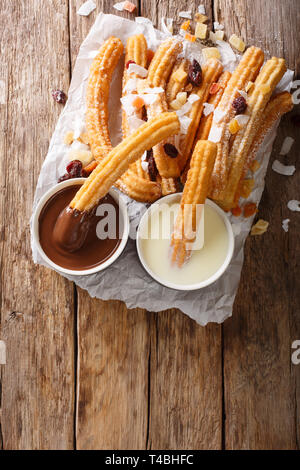 Frisch heiß Churros mit heißer Schokolade und Kondensmilch close-up auf den Tisch. Vertikal oben Ansicht von oben Stockfoto