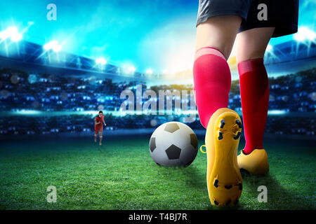 Ansicht der Rückseite des Fußball-Spieler Frau Dribbling den Ball auf und den Umgang mit ihrer Gegnerin auf dem Fußballfeld bei Stadion Stockfoto