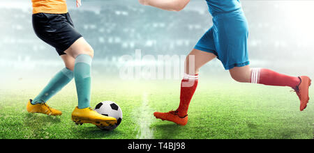 Fußballspieler Frau rollt der Ball beim Umgang mit ihrer Gegnerin auf dem Fußballfeld bei Stadion Stockfoto