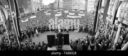 Am 08. Dezember 1963 rund 22.000 zurückkommenden Soldaten mit einem stillen Protest März und einer Kundgebung in Bonn für eine bessere Entschädigung für ehemalige Kriegsgefangene des Zweiten Weltkrieges demonstrieren. Das Bild zeigt die Kundgebung auf dem Marktplatz von Bonn, wo der SPD-Abgeordnete Helmut Bazille gibt eine Rede vor dem Rednerpult. | Verwendung weltweit Stockfoto