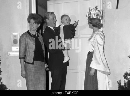 Die 22-jährige Schwedin Agneta Lindvall Besuche der Hohenzollern in München als "Lucia" anlässlich der Schwedischen Saint Lucy's Tag am 11. Dezember 1963. Das Bild zeigt das Agneta Lindvall (R), Prinzessin Birgitta von Schweden (L), Fürst Johann-Georg-von Hohenzollern-Sigmaringen (2. von links) und ihr Sohn Carl Christian in den Armen seines Vaters (2. von rechts). | Verwendung weltweit Stockfoto