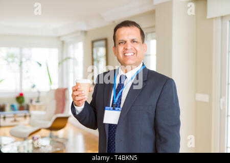 Mittleres Alter Geschäftsmann, trinken eine Tasse Kaffee tragen ID-Karte Stockfoto
