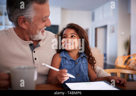 Senior Hispanic Mann mit seiner Enkelin auf Tablet Computer, an einander suchen, Nahaufnahme Stockfoto