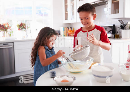 Bruder und Schwester Vorbereitung Kuchenteig gemeinsam am Küchentisch, Taille bis Stockfoto