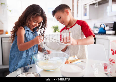 Bruder und Schwester Vorbereitung Kuchenteig gemeinsam am Küchentisch, Taille bis Stockfoto