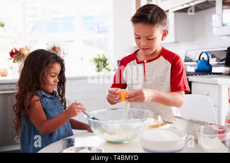 Bruder und Schwester Vorbereitung Kuchenteig gemeinsam am Küchentisch, Taille bis Stockfoto