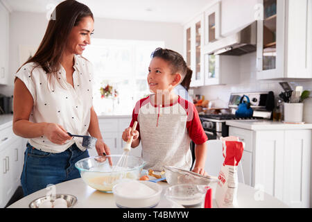 Pre-teen Boy einen Kuchen in der Küche mit seiner Mama, an einander suchen, Nahaufnahme Stockfoto