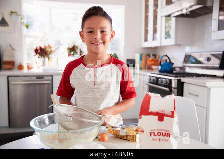 Stolz vor - jugendlich Junge macht Kuchenteig auf seinen Selbst in der Küche, Lächeln, Nahaufnahme Stockfoto