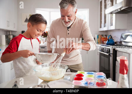 Pre-teen Boy macht Kuchenteig in der Küche mit seinem Großvater, Nahaufnahme Stockfoto