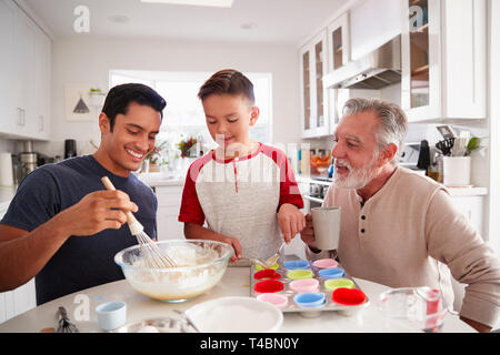 Drei Generationen der Familie Vorbereitung Kuchen zusammen am Tisch in der Küche, in der Nähe Stockfoto