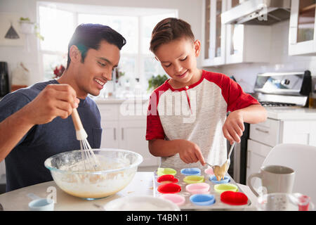 Pre-teen Boy steht am Tisch in der Küche Kuchen, mit seinem Vater, in der Nähe Stockfoto