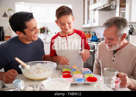 Drei Generationen der Familie und Kuchen zusammen am Tisch in der Küche, in der Nähe Stockfoto