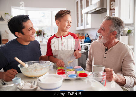 Drei Generationen der Familie und Kuchen zusammen am Tisch in der Küche, in der Nähe Stockfoto