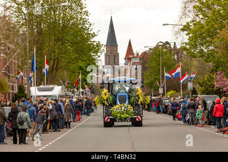 Ein Traktor mit wunderschönen Blumen und viele Zuschauer bei der jährlichen bloemencorso Glühlampe Blumenkorso in der hoofdstraat in der niederländischen Dorf Sass Stockfoto