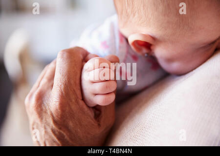 Nahaufnahme von Großvater die Hand seines Babys Enkel, als er ihn hält, Detail, Ansicht Stockfoto