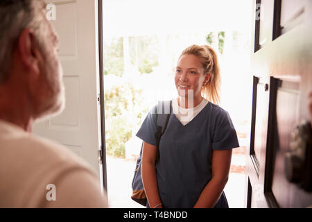 Älterer Mann öffnete seine Tür zu einem weiblichen healthcare Arbeiter eine Home Gesundheit besuchen Sie Stockfoto