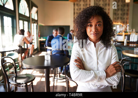 Weibliche Manager des geschäftigen Cocktailbar im Restaurant mit Kunden an Kamera Stockfoto
