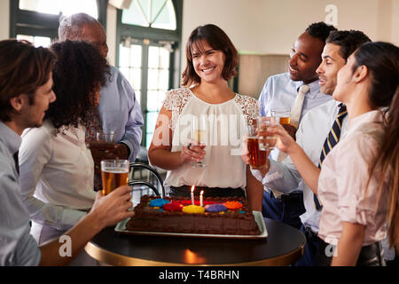 Business Team treffen in Bar zu den weiblichen Kollegen Geburtstag feiern. Stockfoto