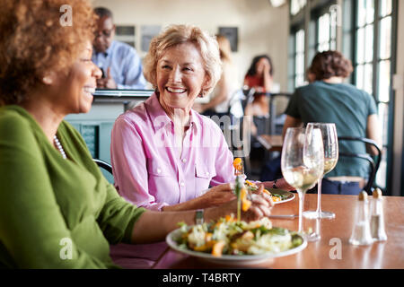 Zwei lächelnde ältere Frauen Treffen für Abendessen in Restaurant Stockfoto