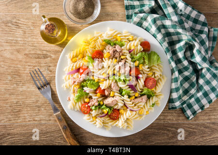 Nudelsalat mit Gemüse und Thunfisch auf Holztisch. Ansicht von oben Stockfoto